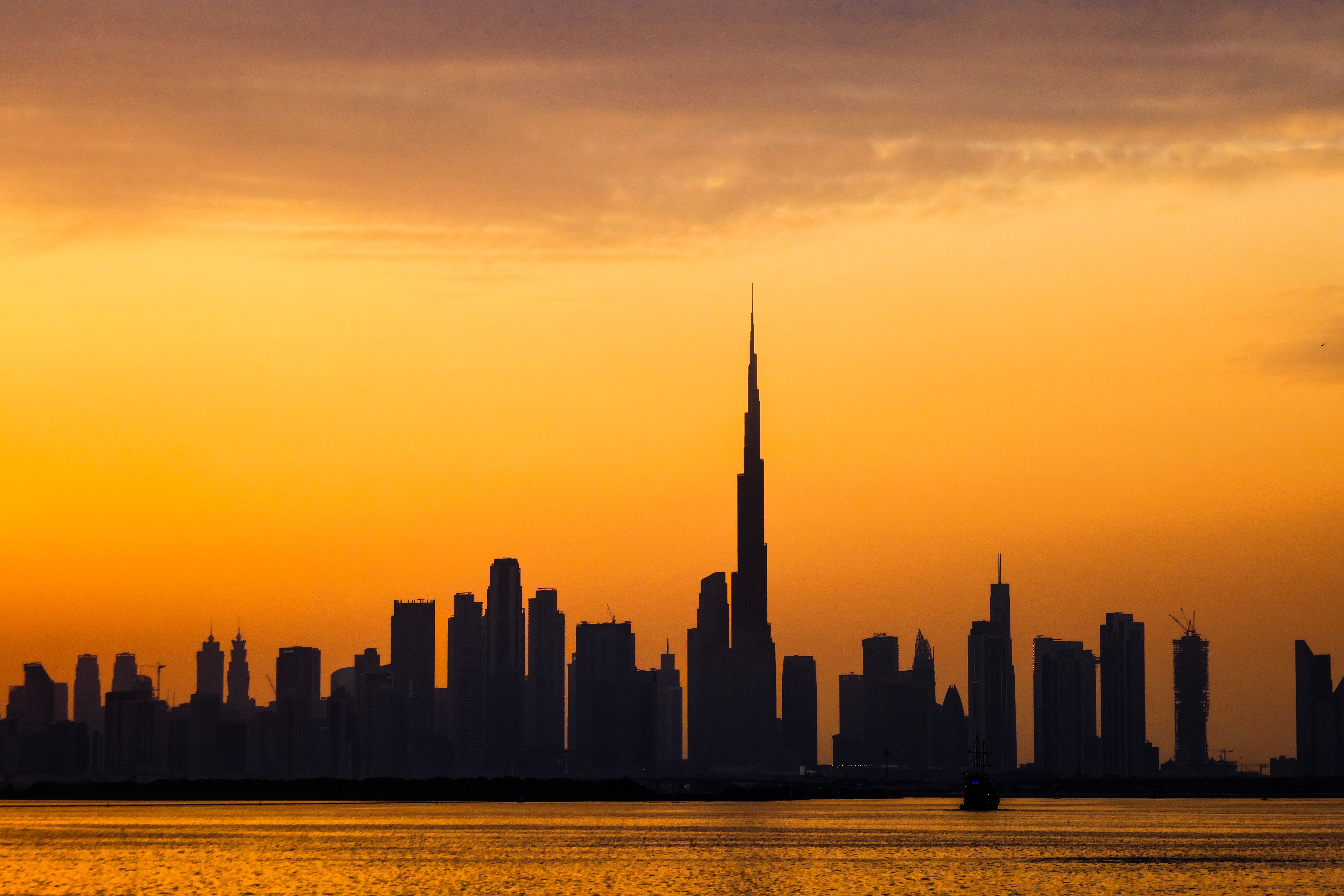 Dubai skyline silhouette across the water at dusk